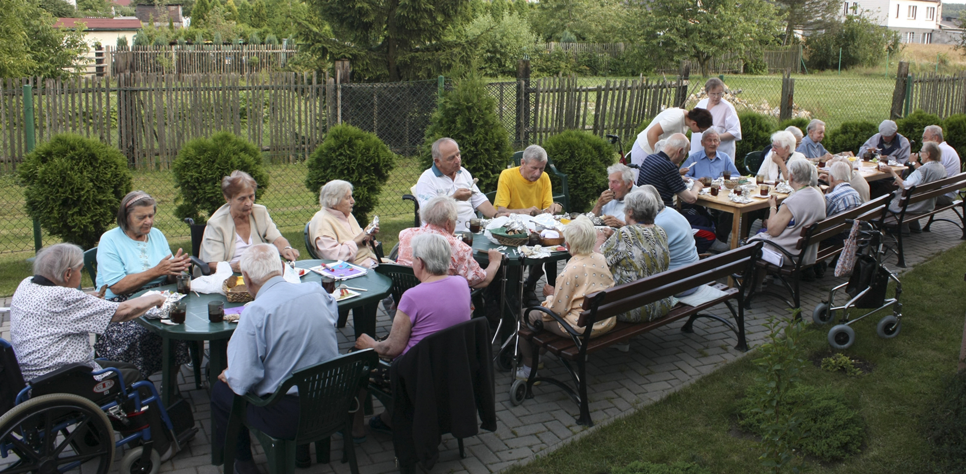 pensjonariusze w trakcie posiłku na świeżym
          powietrzu